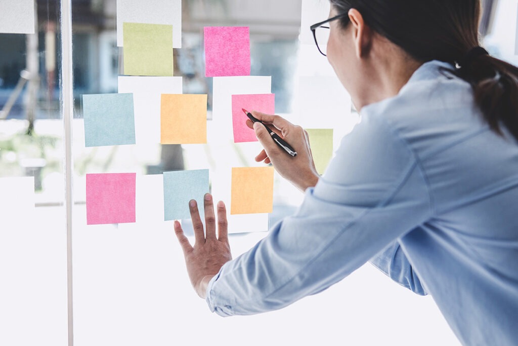 staff member working on outlining the brand vision on multiple sticky notes to make sure it meets the content strategy guidelines