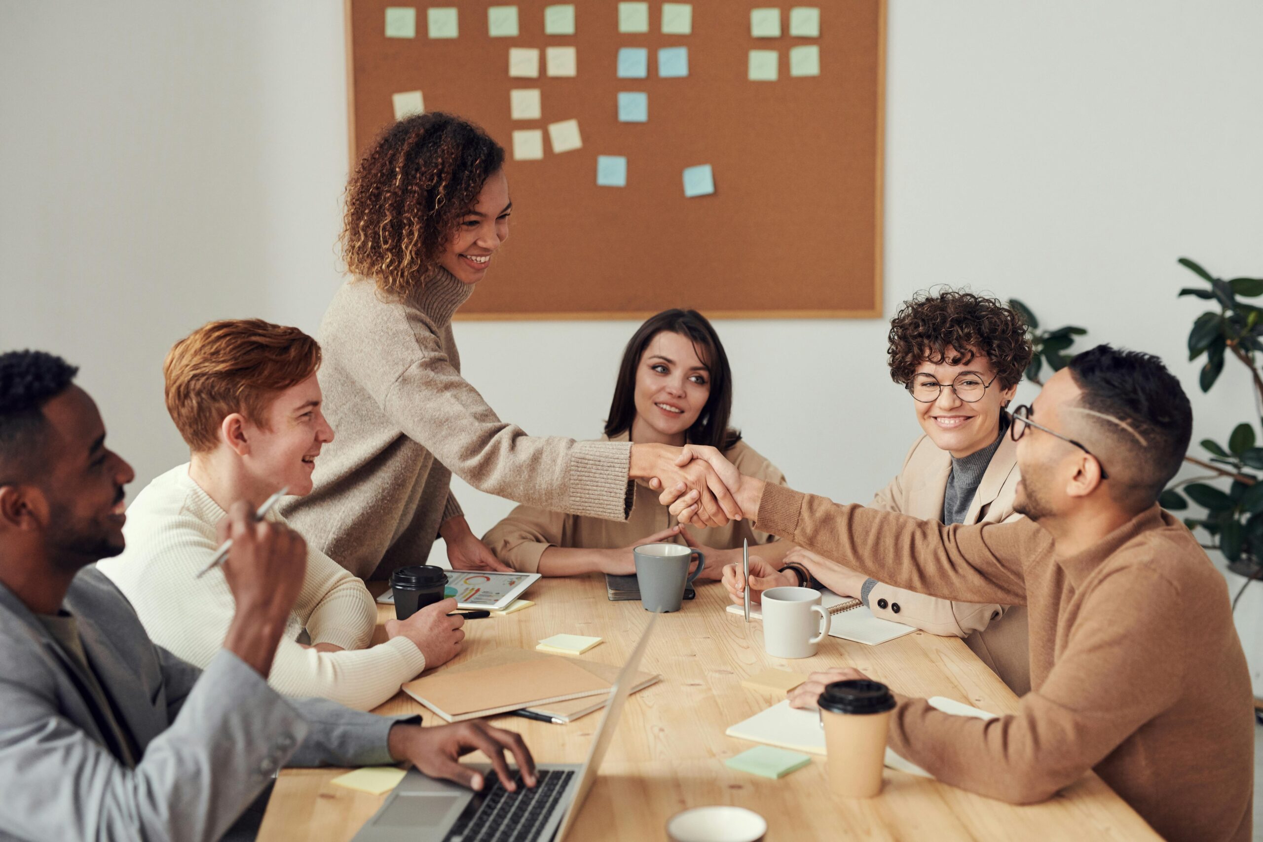 Business owner shaking hands with leader of a small business marketing agency team after a presentation